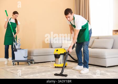 Professionelles Reinigungsteam, das im Zimmer arbeitet Stockfoto