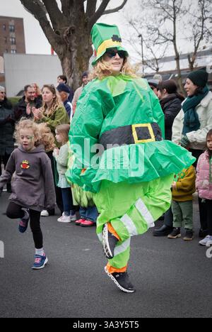 Eine hübsche Frau in einem grünen St. Patrick's Day Fatsuit während der Parade 2025 in Peekskill, New York. Stockfoto