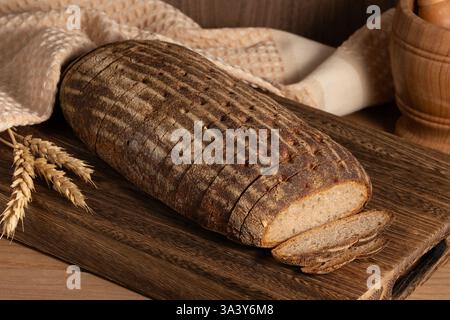 Mehrkörniges Sauerteigbrot mit Leinsamen auf einem Holzbrett, Nahansicht. Gesunde vegane Brotauswahl Stockfoto