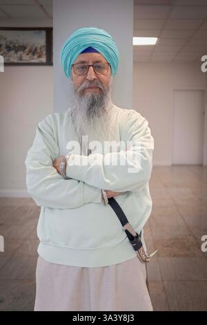 Porträt eines Gläubigen Mannes, der Gegenstände zum Sikhismus außerhalb des Langars in einem Tempel in Queens, New York verkauft. Stockfoto