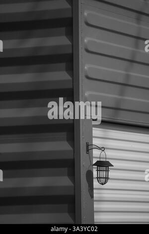 Schwarzweißfotos von der Seite des Versandbehälters, die an der Kante mit Garagentor und Außenbeleuchtung gedreht wurde, die für den Verkaufsstand im Freien in Ontario Canada verwendet werden Stockfoto