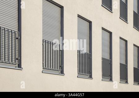 Beige Putzfassade eines modernen Wohnhauses mit geschlossenen Rollläden und französischen Balkonen, Bottrop, NRW, Deutschland, Europa Stockfoto