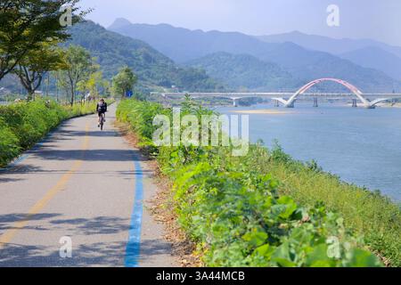 Gwangyang, Südkorea - 3. Oktober 2021: Ein Radfahrer fährt entlang des Seomjingang Bike Path, der parallel zum Seomjin verläuft. Im Hinterland Stockfoto