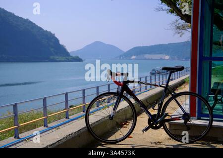 Gwangyang City, Südkorea - 3. Oktober 2021: Ein Rennrad lehnt sich an eine Schutzhütte entlang des Seomjingang Bike Path mit Blick auf den Seomjin River. Die Stockfoto