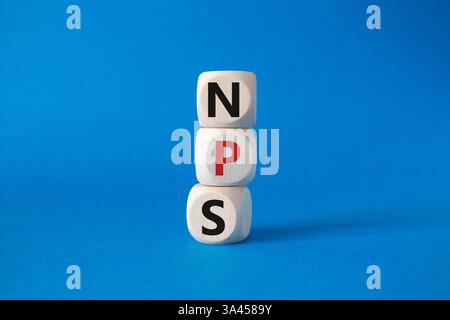 NPS – Net Promoter Score-Symbol. Holzwürfel mit den Worten NPS. Wunderschöner blauer Hintergrund. Business- und NPS-Konzept. Kopierbereich. Stockfoto