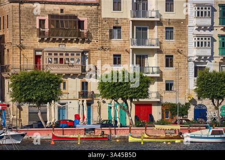 Charmante Stadthäuser am Wasser in Valletta, Malta, mit bunten Balkonen und Booten in einem ruhigen Hafen Stockfoto
