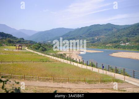 Gwangyang City, Südkorea - 3. Oktober 2021: Ein malerischer Blick auf den Seomjingang Bike Path, der parallel zum gewundenen Fluss verläuft, mit üppig grünem mou Stockfoto
