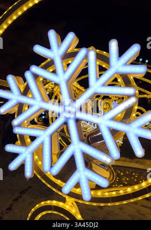 Wunderschöne glühende Weihnachten- und Neujahrsdekoration mit großen abstrakten Schneeflocken auf der Abendstraße Stockfoto