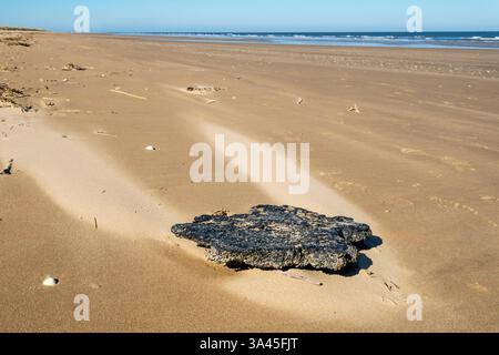 18. März 2025. Kunststoffverschmutzung in Form verbrannter und geschmolzener Nurdles (Pellets aus Kunststoffharz), die an einem Strand von North Norfolk nach der Kollision des Containerschiffs Solong und der Stena Immaculate vor der Mündung von Humber am 10. März 2025 angespült wurden. Stockfoto