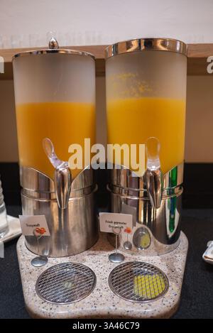 Saftspender aus Edelstahl mit frischem Orangensaft in Österreich Stockfoto