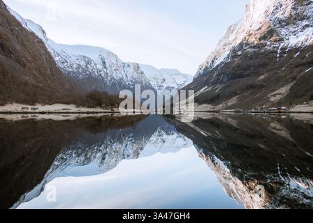 Ein Landschaftsfoto norwegischer Fjorde, wo majestätische schneebedeckte Berge sich im ruhigen Wasser spiegeln. Dieses Bild ist ein ideales Hintergrundbild für Desktops. Stockfoto