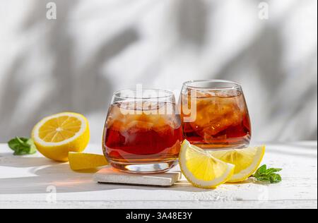 Zwei Gläser Eistee auf einem sonnigen weißen Holztisch Stockfoto