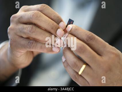 21. Mai 2014 – Milpitas, CA, USA – Sanjay Mehrotra, Mitbegründer, Präsident und CEO von SanDisk, hält am 21. Mai 2014 in seinem Büro am Firmensitz in Milpitas, Kalifornien, eine 128-Gigabyte-microsd-Karte. (Abbildung: © Nhat V. Meyer/MCT/ZUMA Wire) Stockfoto