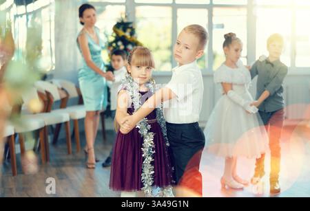 Tween Junge und Mädchen spielen Walzer während der Weihnachtsfeier in der Schule Stockfoto
