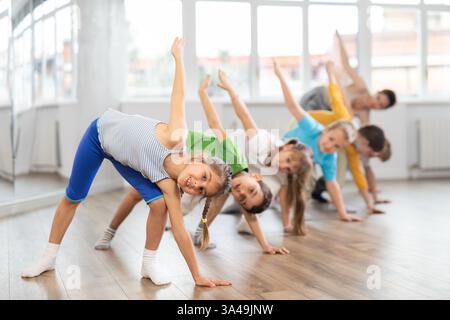 Gruppe von Kindern, die sich vor dem Tanzkurs aufwärmen Stockfoto