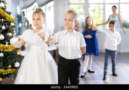 Tween Junge und Mädchen spielen Walzer während der Weihnachtsfeier in der Schule Stockfoto