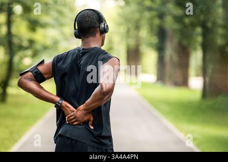 Rückansicht des schwarzen Mannes in Sportkleidung berühren verletzten Rücken Stockfoto