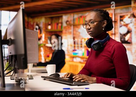 Silicon Valley Venture Engineer löst Aufgaben mit KI LLM Chatbot beantwortet Eingabeaufforderungen mithilfe von Predictive-Technologie. afroamerikanischer IT-Startup-Mitarbeiter, der Computer verwendet, um mit der App für generative Modelle zu interagieren Stockfoto