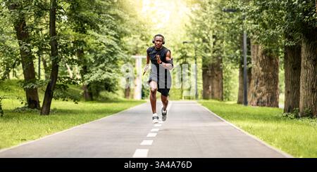 Athletischer afrikanischer Mann, der sich für Marathon im Park vorbereitet Stockfoto
