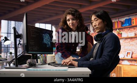 Der Ingenieur des KI-Startups stellt Fragen an den Teamleiter, bevor er mit der Implementierung von maschinellem Lernen beginnt. Mitarbeiter des Technikunternehmens für künstliche Intelligenz bittet um Hilfe vom Manager, um Codefehler zu beheben, Kamera B Stockfoto