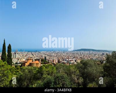 Das breite Stadtbild Barcelonas zeigt die Skyline der Stadt mit der Sagrada Familia und dem Mittelmeer im Hintergrund unter klarem blauem Himmel Stockfoto
