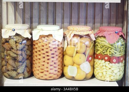 Farbenfrohe Gläser mit konserviertem Obst und Gemüse auf einem Regal Stockfoto
