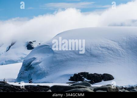 Eine beschauliche antarktische Landschaft in der Nähe des Hafens Mikkelsen auf Trinity Island, mit starken Reflexen, zerklüfteten Bergen und beeindruckenden Eisbergen Stockfoto