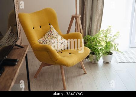 Heller gelber Lesesessel in einem gemütlichen Wohnzimmer. Hochwertige Fotos Stockfoto