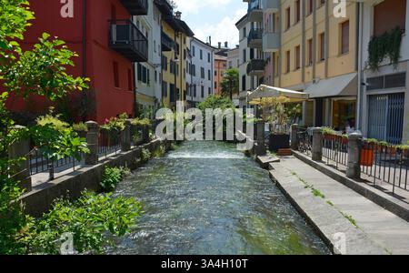 Der Roggia di Udine Kanal, der durch Udine in Friaul-Julisch Venetien fließt, Nordostitalien. Alte Lavatoios oder Waschplatten sind am rechten Ufer. Stockfoto