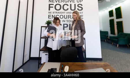 Teammitglieder arbeiten an einem Projekt in einem modernen Bürobereich mit motivierender Einrichtung zusammen Stockfoto