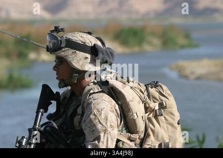 13. Juni 2004; Al Anbar, Irak; Sgt. CYPRIAN D. JOHNSON, 1st Force Reconnaissance Company, 1st Marine Expeditionary Force, aus Camp Pendleton, Kalifornien, beobachtet den Euphratfluss auf Anzeichen von Ärger, während seine Marinekollegen am 13. Juni in der Provinz Al Anbar im Irak mit lokalen Irakern sprechen. Stockfoto
