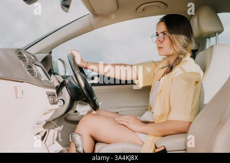 Eine junge Frau, die ein Auto mit einem fokussierten Ausdruck fährt Stockfoto