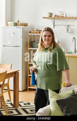 Heller und gemütlicher Raum zeigt eine junge Frau mit Down-Syndrom, die selbstbewusst ihr Zuhause aufgeräumt. Stockfoto
