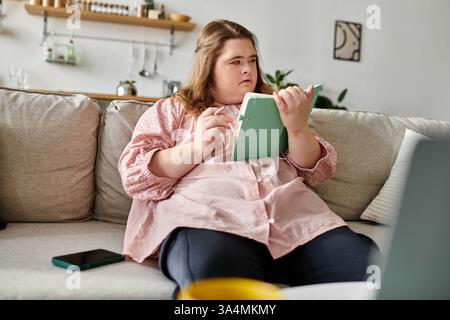 Eine junge Frau mit Down-Syndrom zeigt ihre Kreativität, während sie sich zu Hause mit einem Notizbuch entspannt. Stockfoto