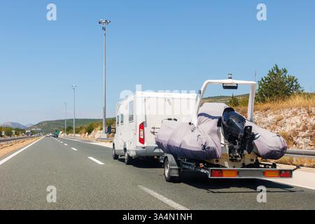 Moderner Luxus-SUV Schleppboot Boot Anhänger Carrier Go River See Meer Urlaub Berg Autobahn Straße Sommer Licht. Luxuriöse Angelausflüge Stockfoto