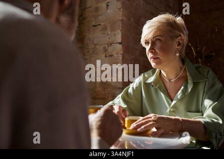 Ein Paar mittleren Alters genießt eine romantische Verabredung und führt tiefe Gespräche Stockfoto