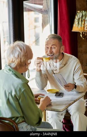 Ein Paar mittleren Alters teilt sich einen intimen Moment bei einem Drink und genießt die Gesellschaft des anderen. Stockfoto