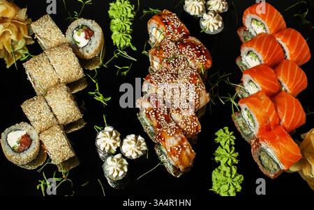 Japanisches Sushi wird auf einem dunklen Tisch gerollt. Draufsicht Stockfoto