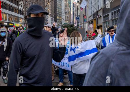 18. März 2025, New York City, New York, Vereinigte Staaten: Ein pro-palästinensischer Protestler gibt zu pro-israelischen Gegenprotestierenden Gesten, während Tausende durch Manhattan marschieren, während sie an einem pro-palästinensischen Protest gegen? Israels erneute Luftangriffe über den Gazastreifen, bei denen über 400 Menschen getötet wurden. Die Angriffe brachen einen vorübergehenden Waffenstillstand mit der Hamas, was die Angst vor einer Rückkehr zu einem vollständigen Konflikt verschärfte. (Kreditbild: © Michael Nigro/Pacific Press via ZUMA Press Wire) NUR REDAKTIONELLE VERWENDUNG! Nicht für kommerzielle ZWECKE! Stockfoto
