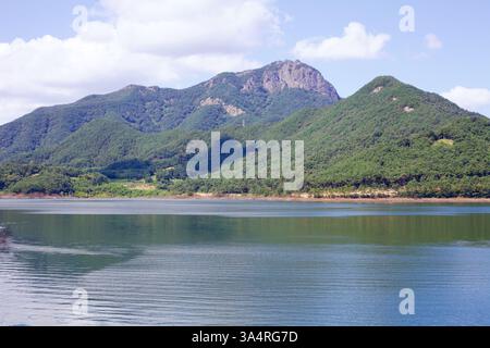 Damyang County, Südkorea - 23. September 2020: Das ruhige Wasser des Damyang Lake reflektiert die üppigen, bewaldeten Hänge des Jeonggak Mountain und bildet ein s Stockfoto