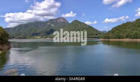 Damyang County, Südkorea - 23. September 2020: Das ruhige Wasser des Damyang Lake spiegelt die üppig grünen Berge um den Stausee und schafft so Stockfoto