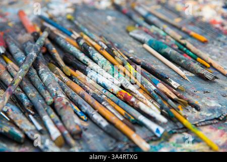 Hintergründe. Nahaufnahme von Künstlerpinseln auf einem Tablett. Draußen. Unordentliche Gruppe von Objekten Stockfoto