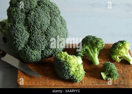 Grüner roher Brokkoli aus biologischem Anbau, bereit zum Kochen auf einem hölzernen Schneidebrett. Gesunde und vegetarische Lebensmittel. Stockfoto