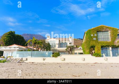Malibu, Kalifornien - 21. Dezember 2024: Luxuriöse Küstenhäuser am Strand von Malibu, umgeben von atemberaubender Landschaft und lebhaftem Grün, neu inszeniert Stockfoto
