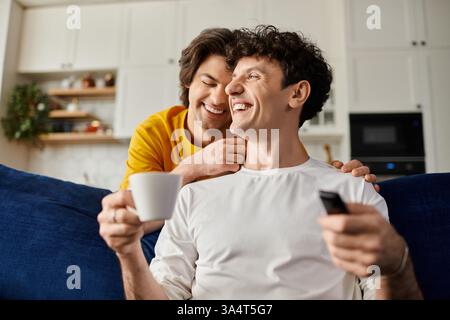 Zwei schwule Männer teilen fröhliche Momente in ihrem stilvollen Apartment, in dem sie Liebe und Verbundenheit genießen. Stockfoto