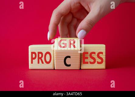 Symbol für Prozess und Fortschritt. Die Hand des Geschäftsmannes dreht Holzwürfel und ändert das Wort Prozess und Fortschritt. Schöner roter Hintergrund. Business und Profi Stockfoto