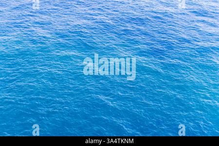 Ein beruhigender Blick auf die Meeresoberfläche, der unter Sonnenlicht sprudelndes Wasser in leuchtenden Blautönen zeigt und Entspannung, Natur und Ruhe betont Stockfoto