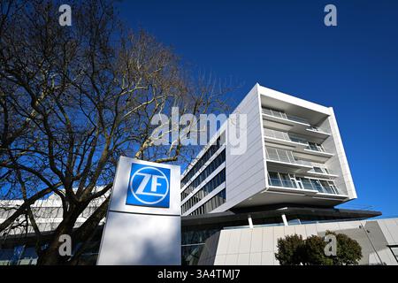 Friedrichshafen, Deutschland. März 2025. Das ZF Friedrichshafen Forum wird von der Abendsonne beleuchtet, im Vordergrund steht eine Stele mit dem ZF Friedrichshafen Logo. Quelle: Felix Kästle/dpa/Alamy Live News Stockfoto