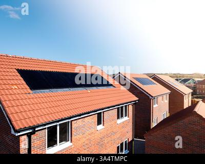 Das Dach einer Reihe neuer Häuser auf einer Baustelle mit integriertem Dach oder in-Dach-Solarpaneelen für billige und nachhaltige Energie in einem Öko f Stockfoto