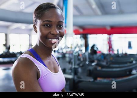 Selbstbewusste Frau im Fitnessstudio lächelnd, in der Nähe von Laufbändern stehend, bereit für das Training, Kopierraum Stockfoto